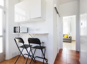 two black chairs in a kitchen with a microwave at Casa Raxón Ferrol in Ferrol