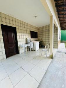 a patio with chairs and a table and a refrigerator at Casa do Carol Sana in Macaé