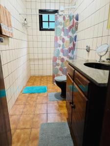 a bathroom with a toilet and a sink and a shower at Casa do Carol Sana in Macaé +15 photos