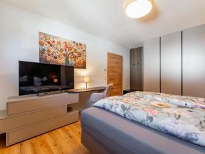 a bedroom with a bed and a flat screen tv at Bruggerheim in Niedernsill