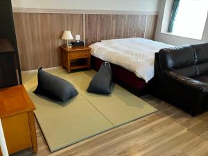 a bedroom with a bed and a leather couch at セントロ大隅ホテルオオサキ in Kanoya