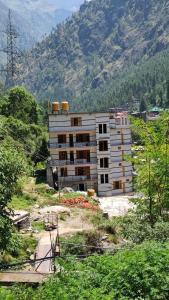 Ein im Bau befindliches Gebäude vor dem Hintergrund der Berge in der Unterkunft Parvati's Edge in Kasol