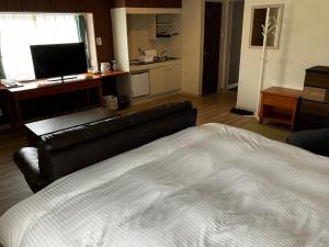 a living room with a bed and a couch at セントロ大隅ホテルオオサキ in Kanoya