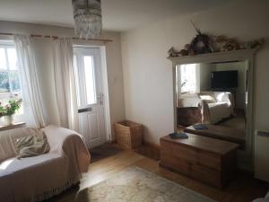 a living room with a mirror and a bed at Priory Cottage Castle Acre in Castle Acre +27 photos
