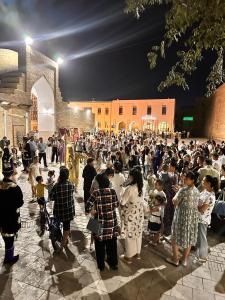 a large crowd of people standing in front of a building at OROM PONORAMA VIEW old city in Bukhara +88 photos