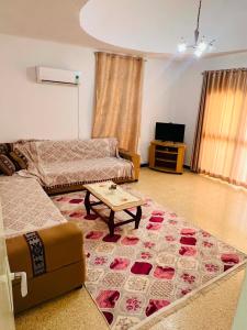 a living room with a couch and a coffee table at maison hajji in Mezraya