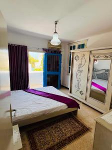a bedroom with a large bed with a mirror at maison hajji in Mezraya