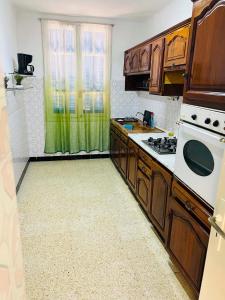a kitchen with wooden cabinets and a white stove top oven at maison hajji in Mezraya