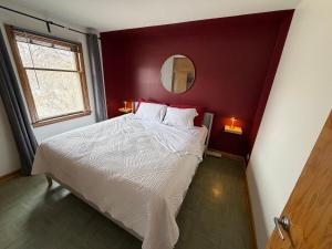 a bedroom with a large bed with a red wall at Merlot House in Calgary