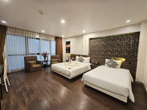 a hotel room with two beds and a chair at Moon Luxury Hotel in Hanoi