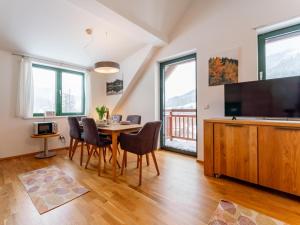 a dining room with a table with chairs and a flat screen tv at Passhöhe in Hohentauern