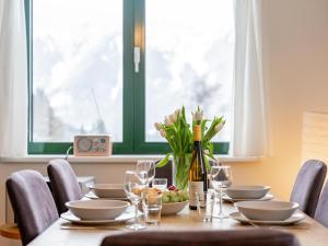 a table with a bottle of wine and a vase of flowers at Passhöhe in Hohentauern