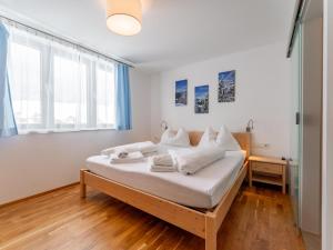 a bedroom with a bed with white sheets and pillows at Passhöhe in Hohentauern