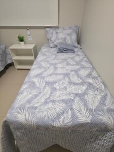 a bedroom with a bed with a white and gray comforter at Refúgio à Beira-Rio em Condomínio Exclusivo in Barreirinhas +96 photos