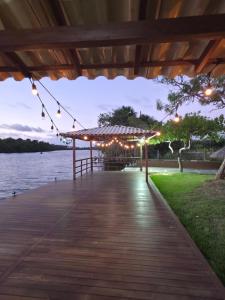 a dock with lights and a pavilion at night at Refúgio à Beira-Rio em Condomínio Exclusivo in Barreirinhas
