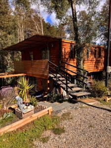 a log cabin in the woods with a tree at Cabaña en el bosque, Valdivia in Valdivia