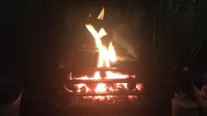 a fire in a brick oven in the dark at Priory Cottage Castle Acre in Castle Acre