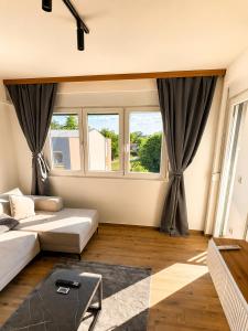 a living room with a couch and a large window at Emperus Spa in Veliko Gradište