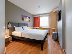 a hotel room with a large bed and a television at ibis Hotel Köln Airport in Cologne +37 photos