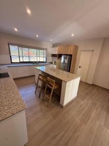 a kitchen with a counter and a table with chairs at Casa Las Moras in Santiago del Estero +3 photos