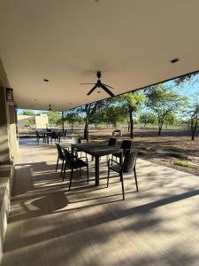 a patio with a table and chairs and trees at Casa Las Moras in Santiago del Estero
