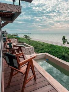 a deck with chairs and a swimming pool on the beach at Danselis Boutique Hotels in Telchac Puerto