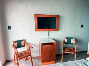 a room with two chairs and a tv on a wall at Danselis Boutique Hotels in Telchac Puerto +15 photos