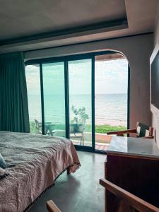 a bedroom with a bed and a view of the ocean at Danselis Boutique Hotels in Telchac Puerto