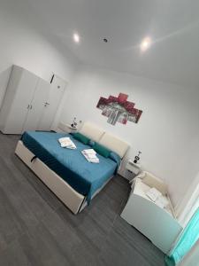 a bedroom with a bed with a blue comforter at B & B Yaya in Taranto +7 photos