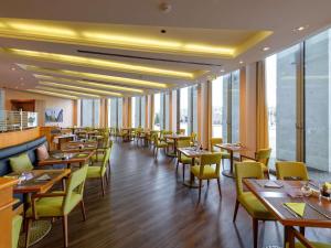 a restaurant with tables and chairs and windows at Novotel Freiburg am Konzerthaus in Freiburg im Breisgau