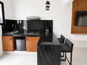 a kitchen with a black counter and a sink at Lucmar Jardín boutique in Cuernavaca