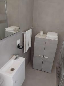 a white bathroom with a sink and a mirror at Cozy Burgau in Burgau