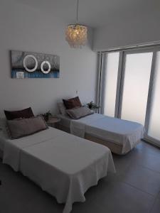 a room with two beds and a table and windows at Cozy Burgau in Burgau