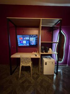 a table and a chair in a room with a tv at Morada do Boto in Santarém