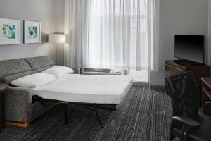 a hotel room with a couch and a tv at TownePlace Suites by Marriott Springfield in Springfield