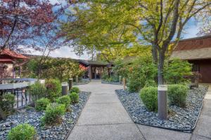 a walkway through a garden with trees and bushes at Best Western Sunridge Inn & Conference Center in Baker City