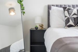 a bedroom with a white bed with a gray headboard at The Mersey Sanctuary in Liverpool +12 photos