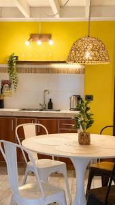 a table and chairs in a kitchen with a yellow wall at Cabañas Sublime Bolson in El Bolsón
