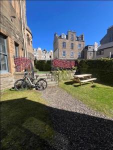 a bike parked in the grass next to a building at Dundee Beds in Dundee