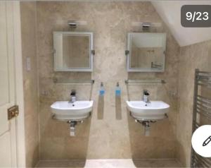 a bathroom with two sinks and two mirrors at Dundee Beds in Dundee +13 photos