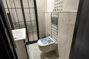 a bathroom with a toilet with a blue and white seat at Kral As Suite Hotel in Istanbul