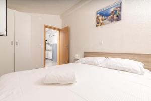 a white bed with white sheets and pillows in a bedroom at Seaside secluded apartments Cove Virak, Hvar - 12321 in Gdinj