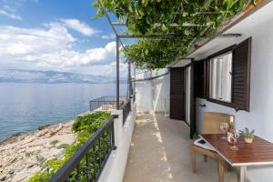 a balcony with a table and a view of the water at Seaside secluded apartments Cove Virak, Hvar - 12321 in Gdinj