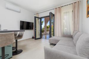a living room with a couch and a television at Apartments by the sea Balica Rat, Omis - 1065 in Omiš