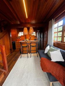 a living room with a couch and a kitchen at VENTO A GOSTO Chalet - Atins in Atins
