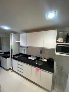 a kitchen with white cabinets and a sink at Sol e Mar Solar do Atlântico-Tambaú-João Pessoa in João Pessoa