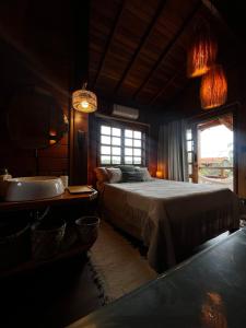 a bedroom with a bed and a tub and a window at VENTO A GOSTO Chalet - Atins in Atins