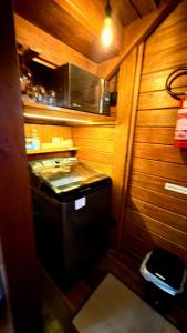 a small kitchen with wooden walls and a stove at VENTO A GOSTO Chalet - Atins in Atins +16 photos