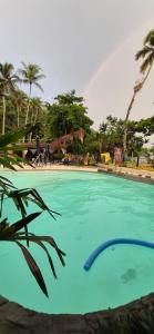 a large swimming pool with a rainbow in the background at Pousada Cabanas Paraiso in Ilha Grande