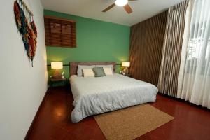 a bedroom with a bed and a green wall at Alma Terra Campestre in Ginebra